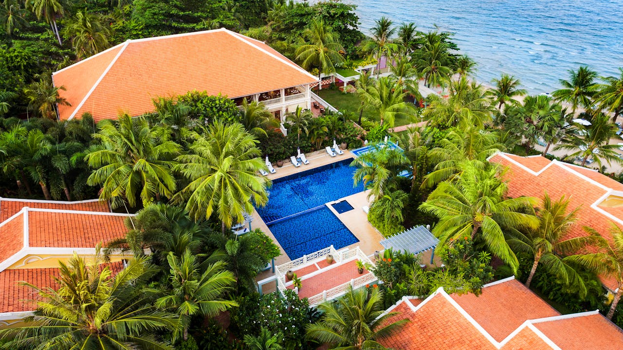 Aerial view of a luxurious tropical resort with a pool and ocean view in Vietnam.