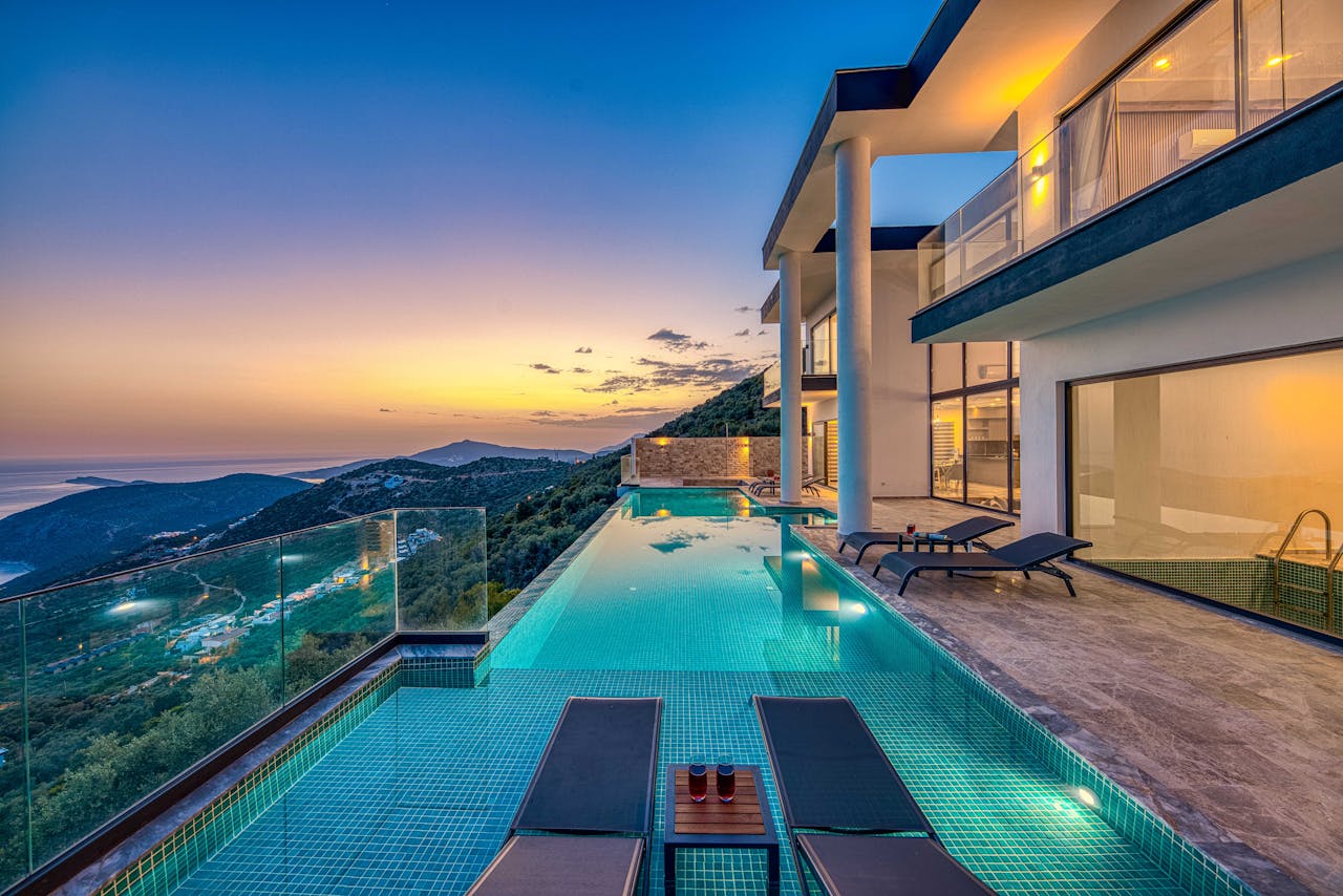 Stunning luxury villa overlooking the ocean with an infinity pool at sunset.